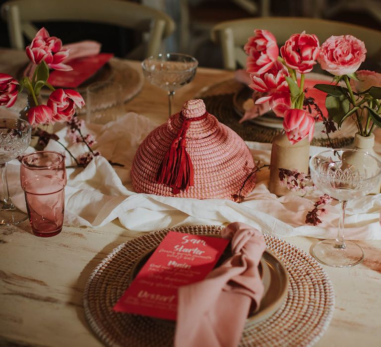 wicker place mat place setting with pink linen napkin and contemporary pink menu card wedding stationery