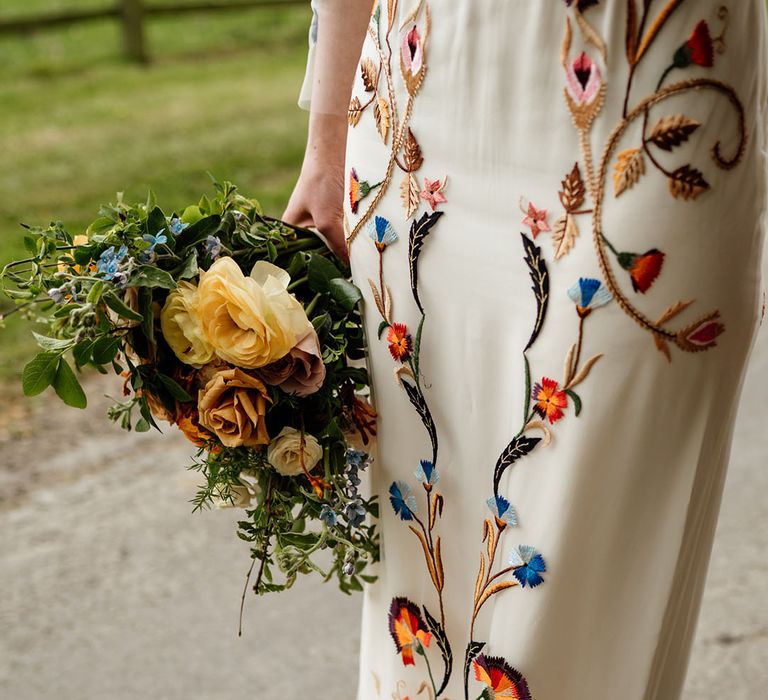 Close up of the colourful details on the bride's wedding dress from Temperley Bridal 