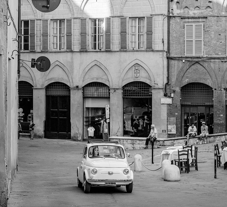 Bride rides in vintage Fiat 500 through Tuscany to church on her wedding day