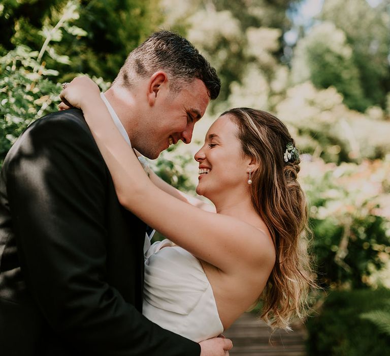 Bride & groom look lovingly at one another during couples portraits outdoors on their wedding day