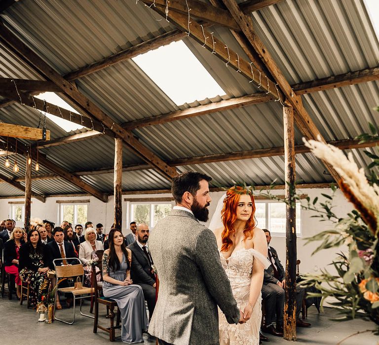 Bride and groom stand on a red rug for their wedding ceremony 