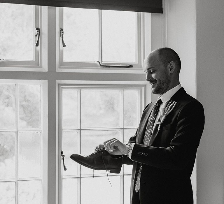 Groom gets ready and puts his shoe son for his wedding 