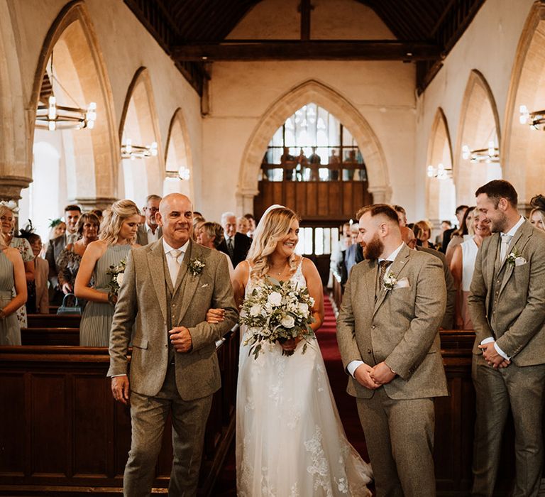 The groom smiles as he sees the bride for the first time 