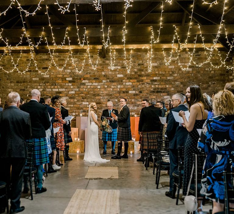 Fairy lights hang from ceiling during industrial styled wedding at The Engine Works Glasgow 