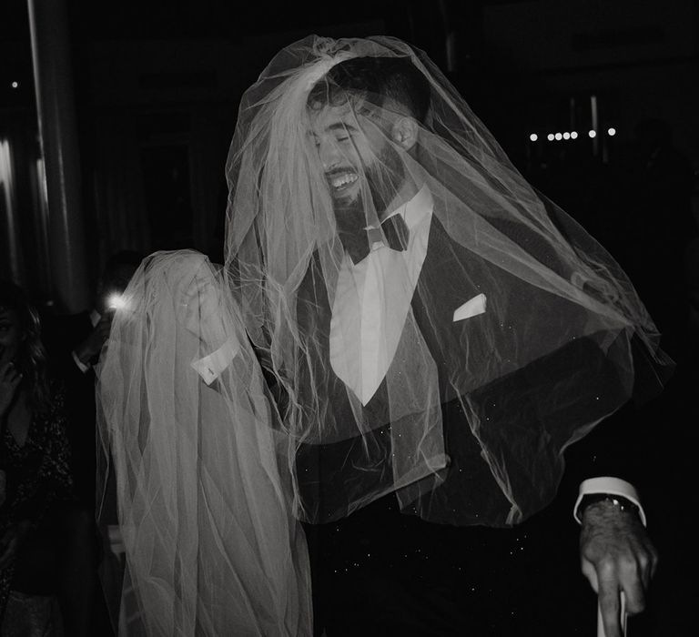 Groom in a tuxedo wearing a wedding veil 