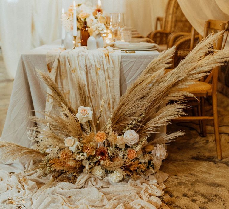 dried grass and muted flower arrangement at wedding table scape 