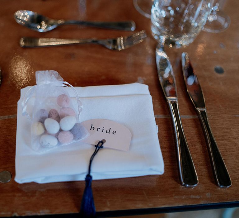 Simple and minimal wedding place name table setting with a small bag of Mini Eggs for the wedding favours at spring April wedding 