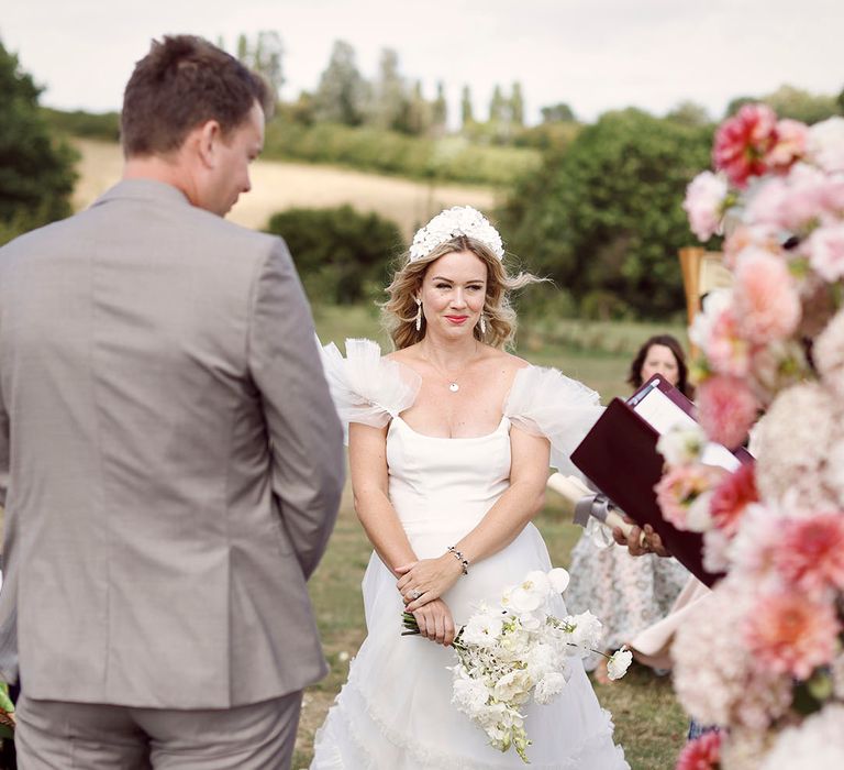 Bride in Halfpenny London wedding dress with white wedding flower bouquet wearing a white flower bridal crown and dangly white earrings 