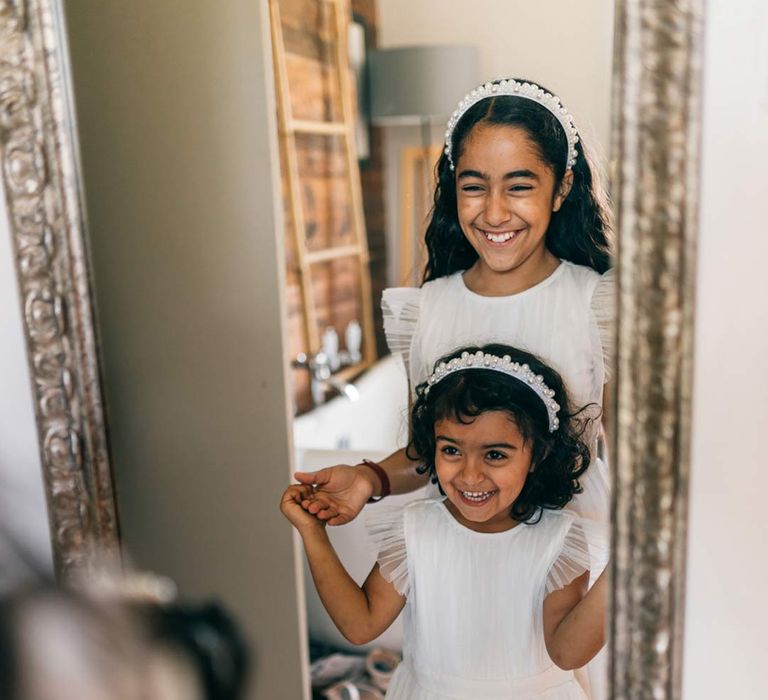 Flower girls wearing white tulle and mesh flower girl outfits at fusion wedding at Templars Barn 