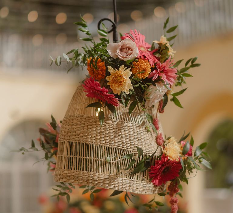 wicker hanging installation and brightly coloured flower hanging decoration 