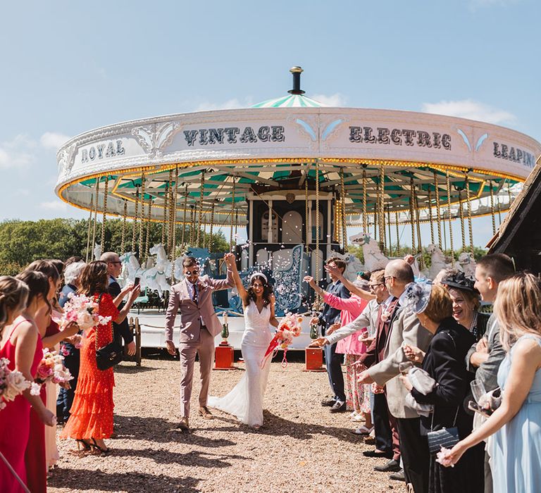 The bride and groom have fun confetti exit from vintage carousel at Preston Court 