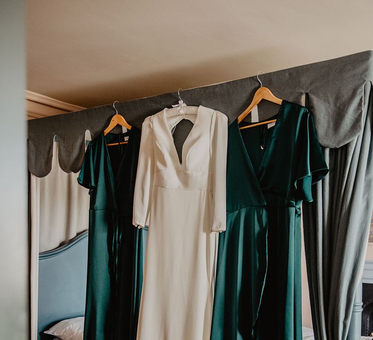 Satin dark green Rewritten Bridesmaid dresses on a hanger with Sassi Holford wedding dress 