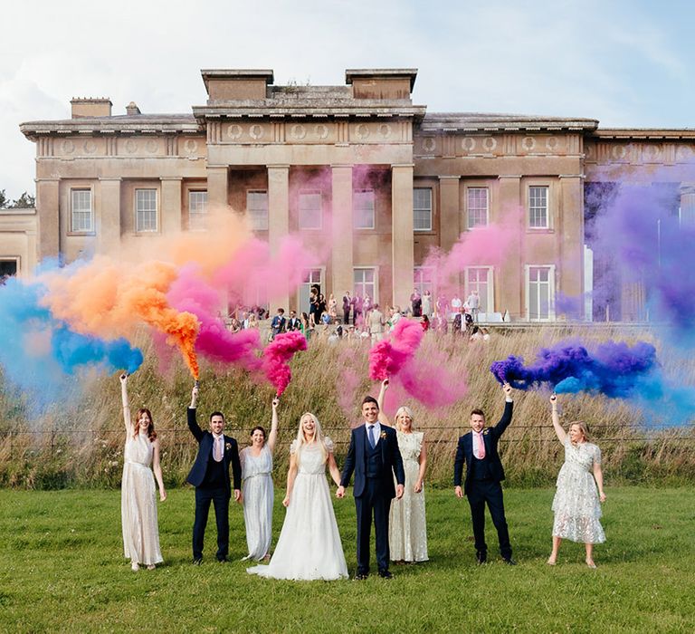 Colourful rainbow smoke bomb photo with the bride and groom and their wedding party 