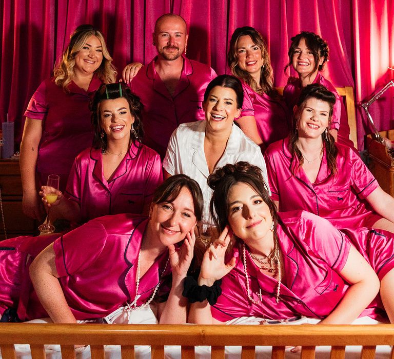 Bridal party in hot pink pyjamas with bridesman in mixed gender wedding party 