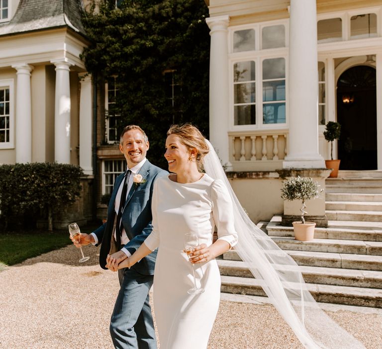 Bride and groom sip champagne at their Pylewell Park wedding