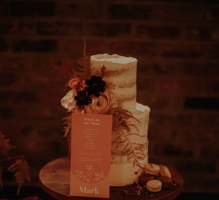 Semi naked wedding cake with orange sign and wood cake stand 