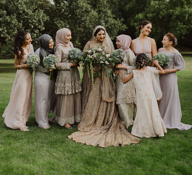 Bridal party portrait with bridesmaids in pastel dresses and saris' for multicultural wedding 