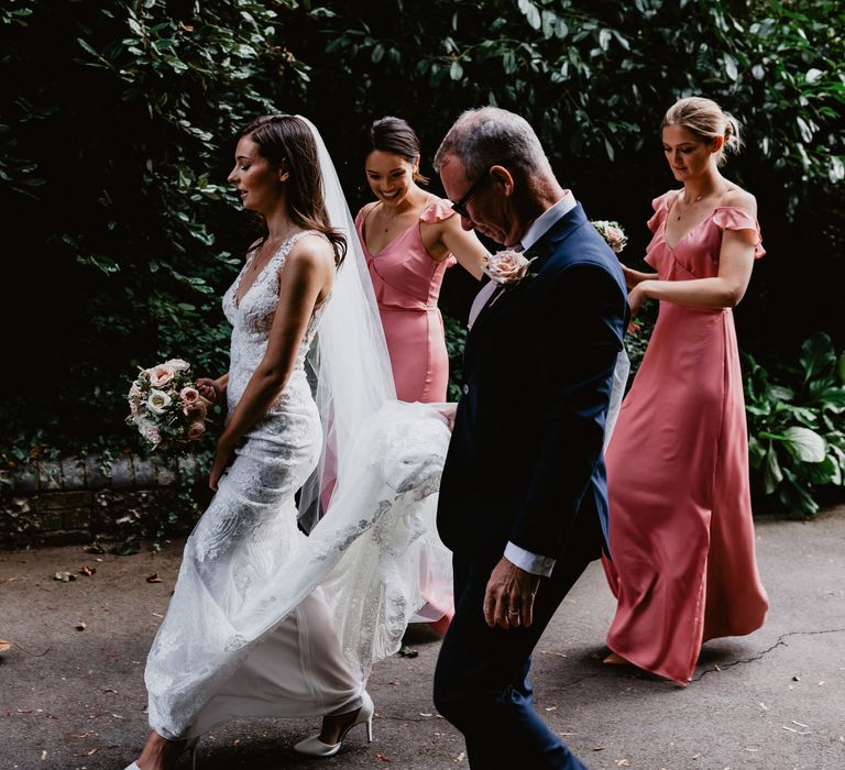 Bride walking with wedding party 