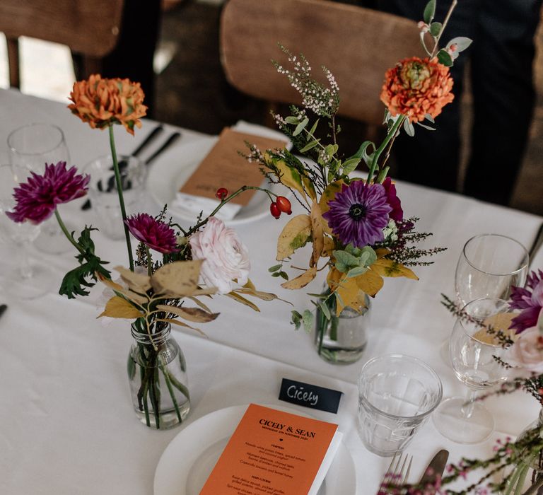 Bright flower and stationery wedding table decor at London pub wedding