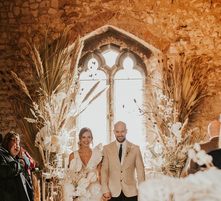 Bride and groom walking up the aisle as husband and wife