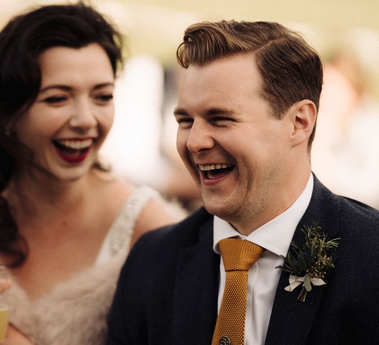 Bride & groom laugh during wedding reception speeches