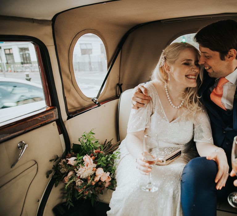 Bride & groom in vintage wedding car 