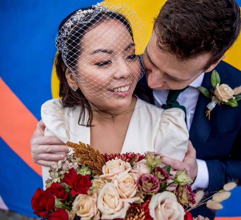 Beautiful Asian bride with subtle makeup up and birdcage veil bridal accessories 