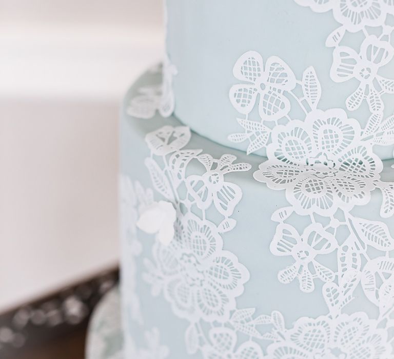 Close up of delicate white lace icing on blue wedding cake