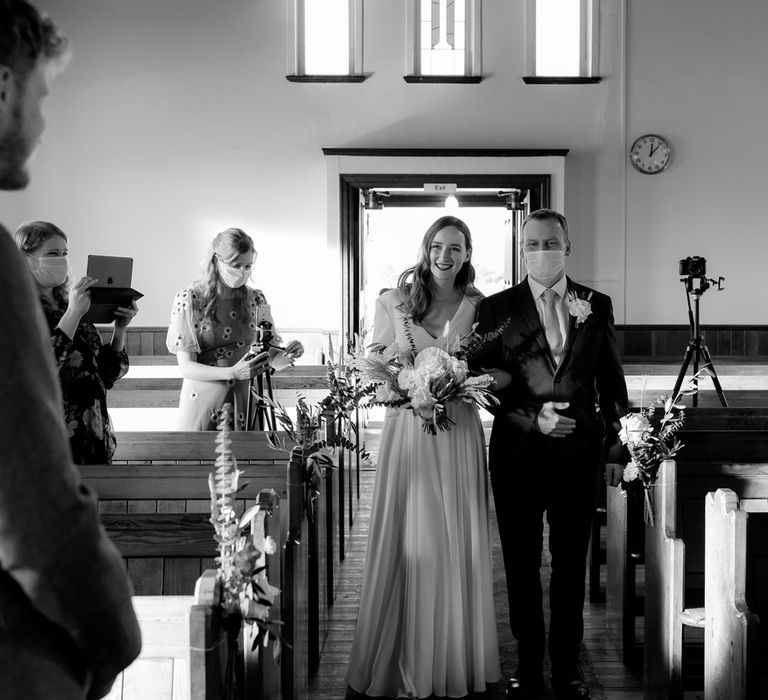 The bride's father walking her down the aisle of the church