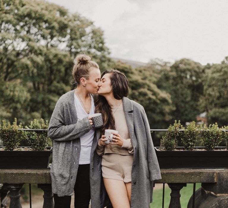 The brides outside with coffee in their pyjamas before their Peak District Elopement