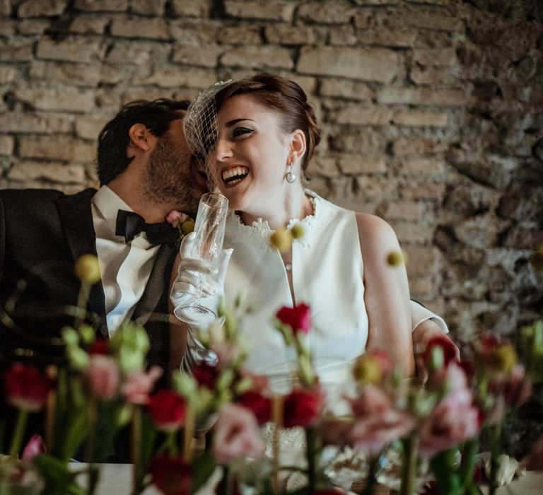 The bride and groom laughing at their intimate reception dinner for four