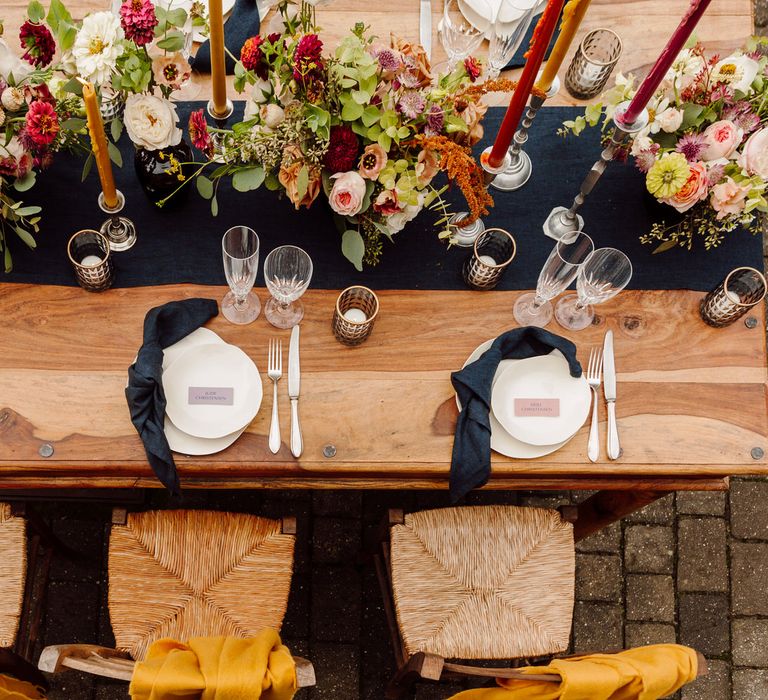 Outdoor wedding tablescape for Tuscany wedding with blue linens, white tableware and earthy toned florals