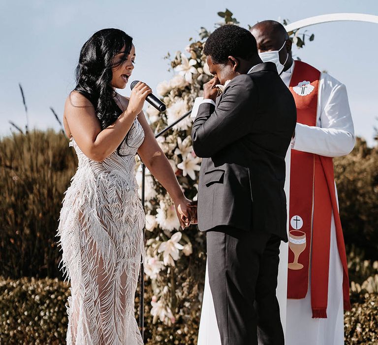 Bride in a strapless Biji La Maison de Couture wedding dress reading her wedding vows to her emotional groom