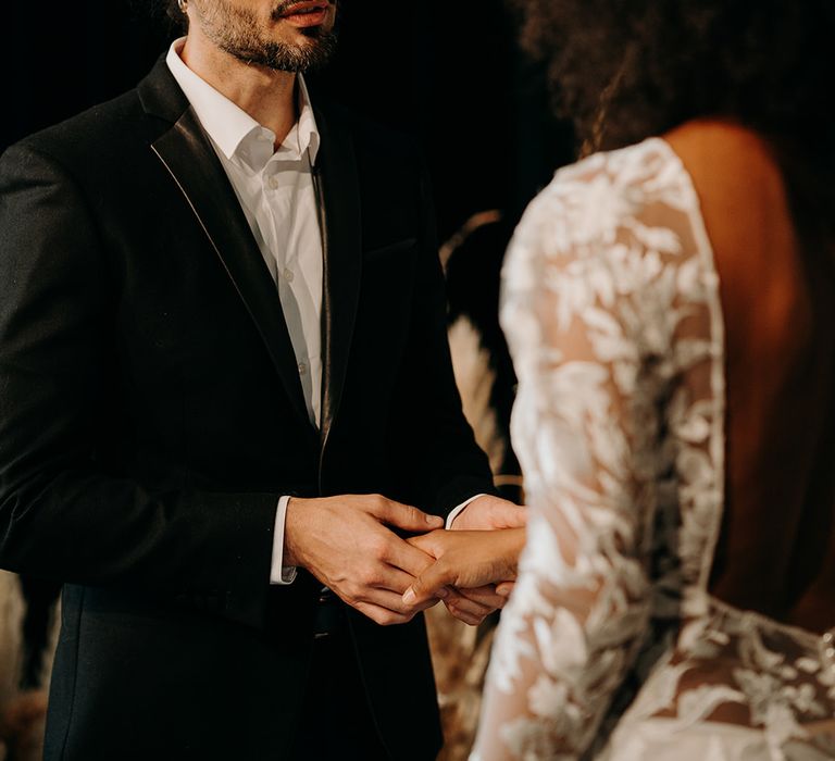 Groom takes brides hand on the day of their wedding 