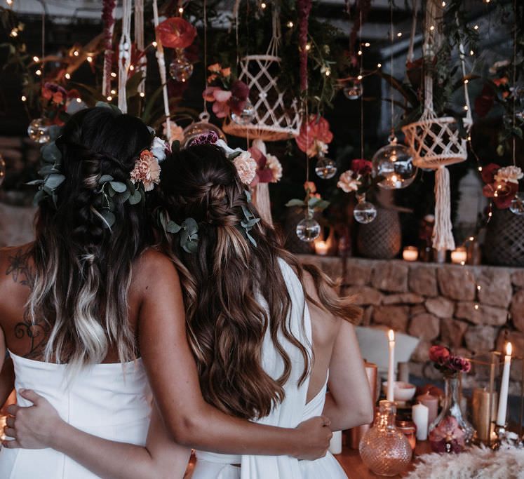 Two brides arm in arm with long flowing wedding hair in beachy waves