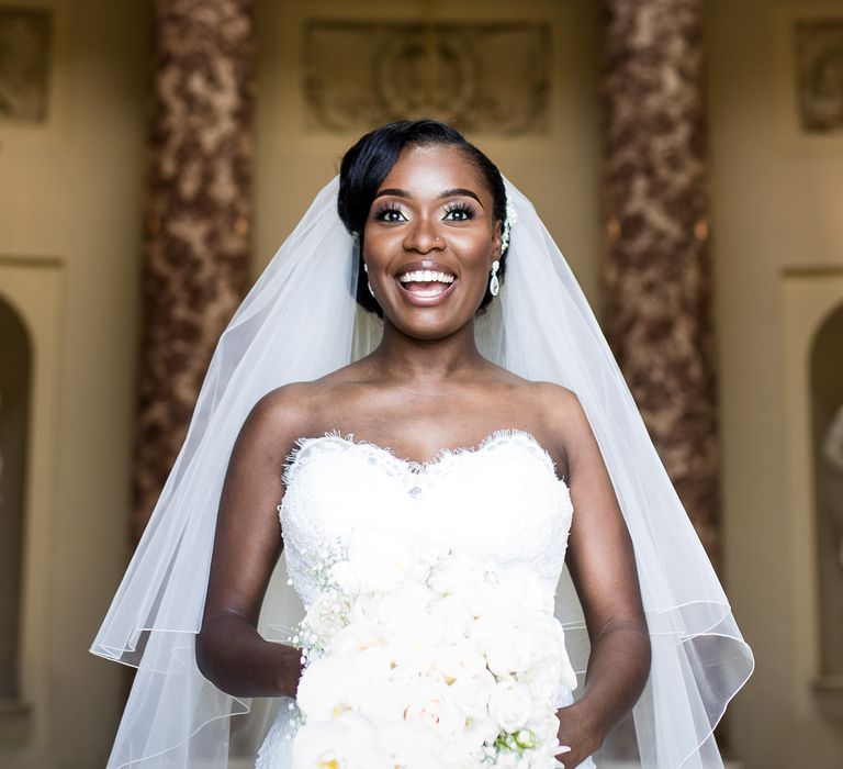 Black bride smiles brightly on her wedding day whilst wearing sweetheart neckline bridal gown