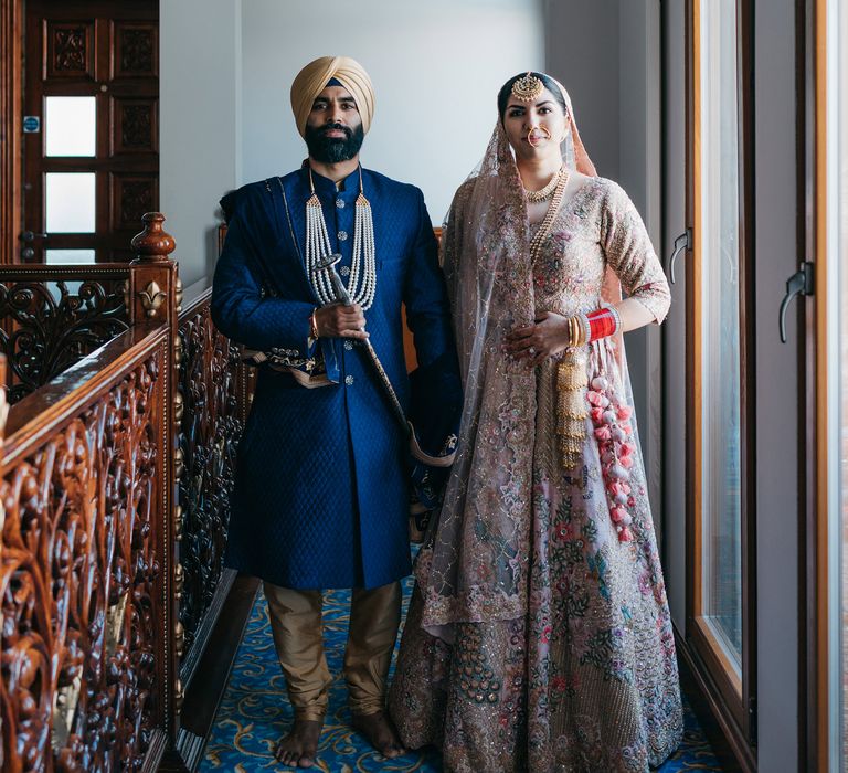 Bride & groom stand together in hallway on their wedding day