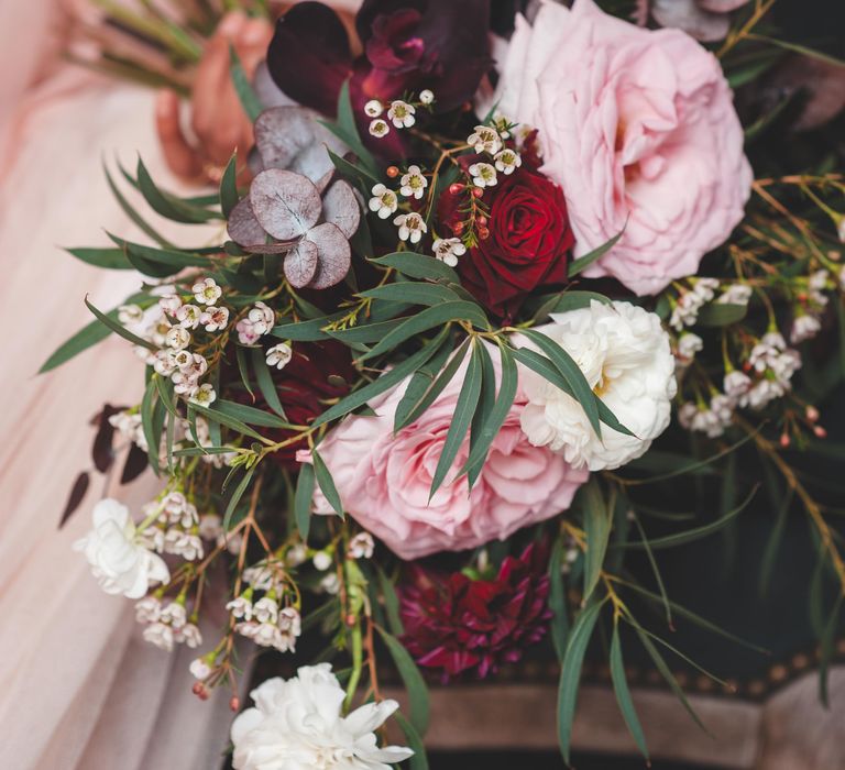 Deep red, pink and white rose wedding bouquet with green foliage 