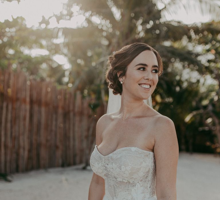 Bride smiles and looks over her shoulder whilst wearing sweetheart neckline 