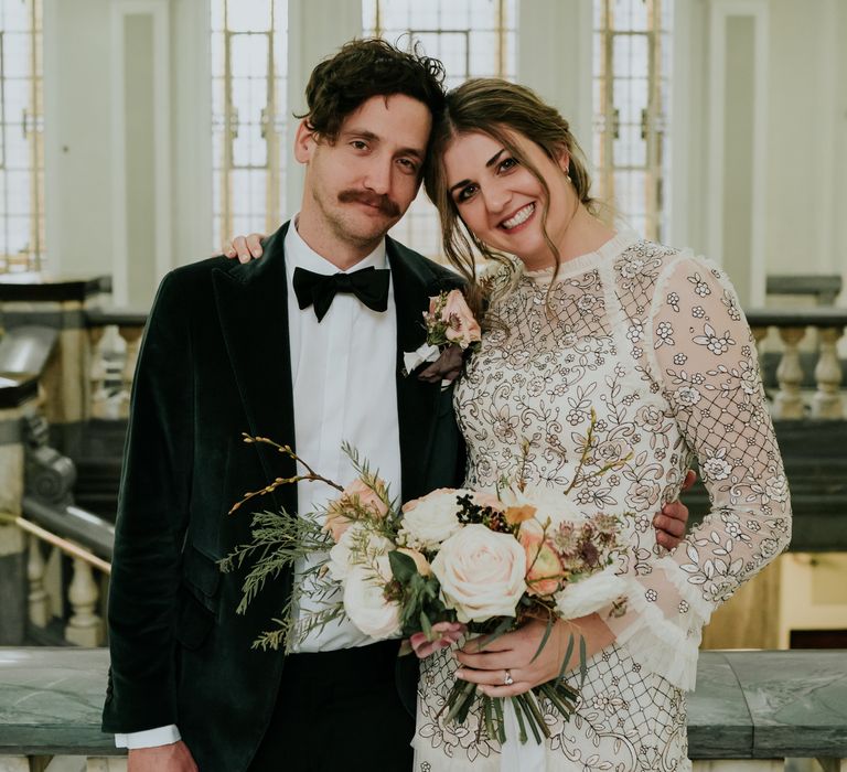 Bride leans her head onto groom as they pose for post wedding ceremony photos