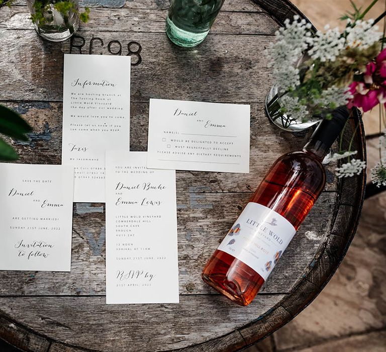 Wedding stationery suite resting on a wooden barrel 