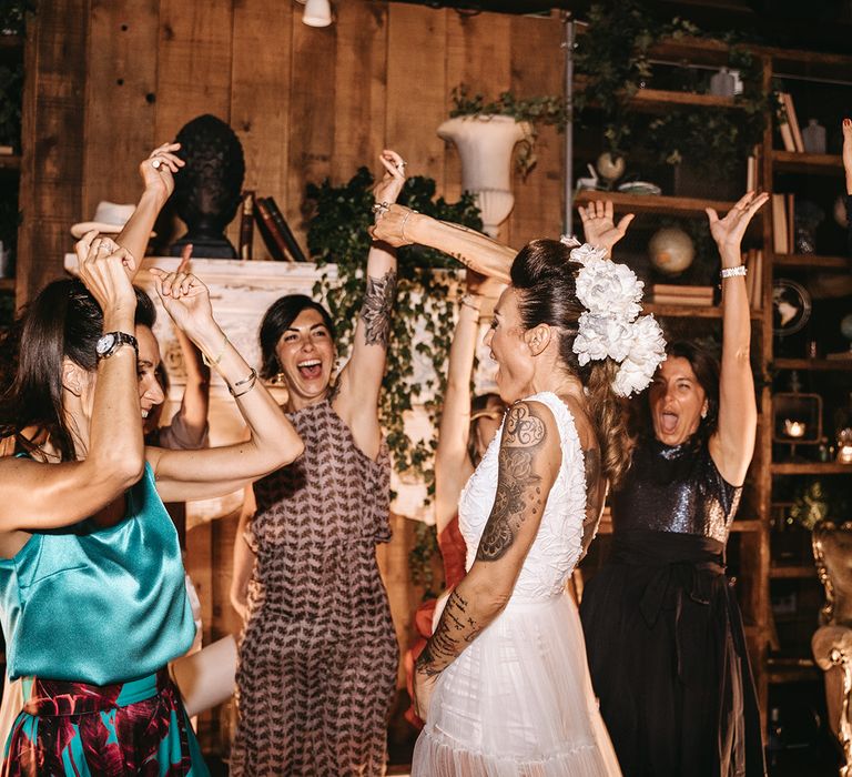 Bride dances during wedding reception in new reception gown and with white flowers in her hair