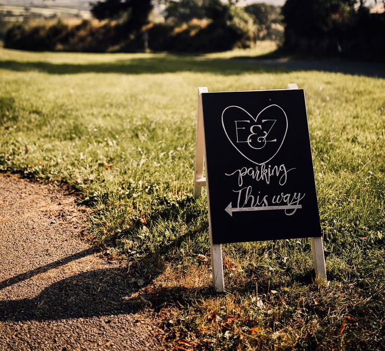 Chalkboard wedding welcome sign in field for Cornwall garden wedding with Halfpenny London Mayfair dress