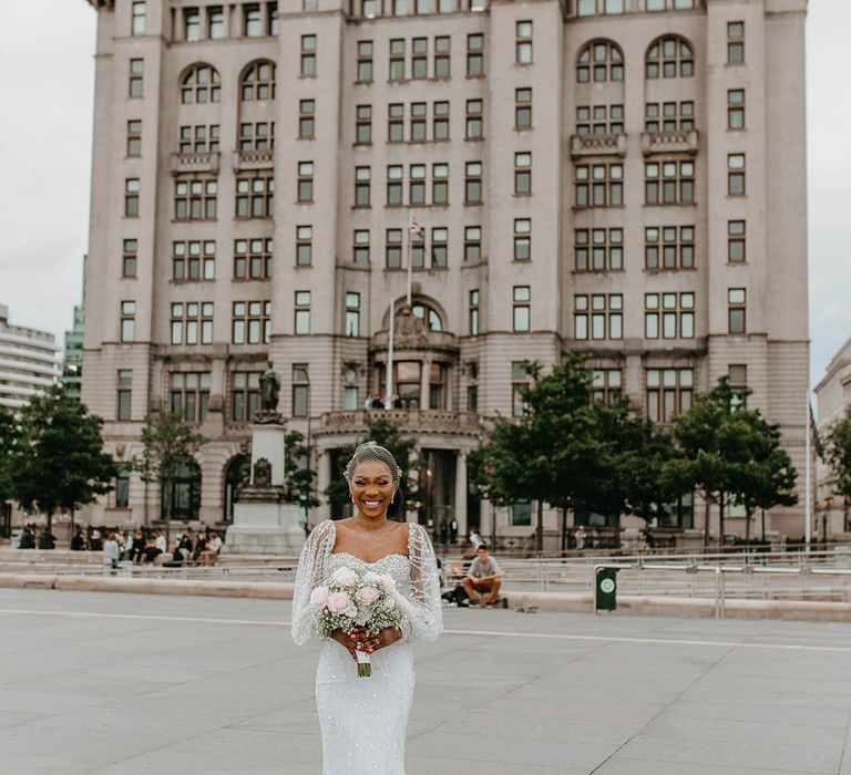 Bride stands outside on her wedding day in custom made wedding gown