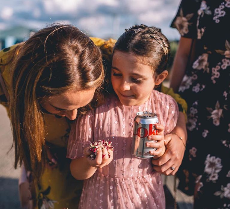 Girl at wedding clutches a handful of confetti 