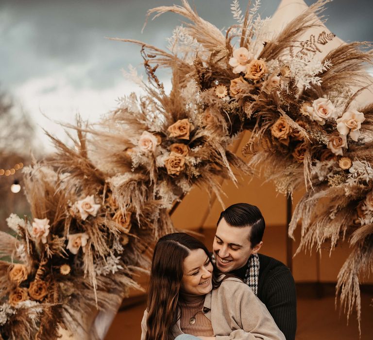 Bell tent decorated with dried and fresh flowers including pampas glass and roses 