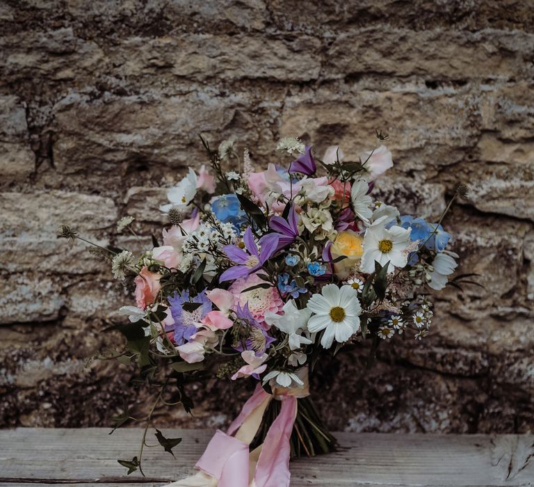 Purple, white and blue bridal bouquet with summer florals tied with white and pink ribbon for Costwolds wedding