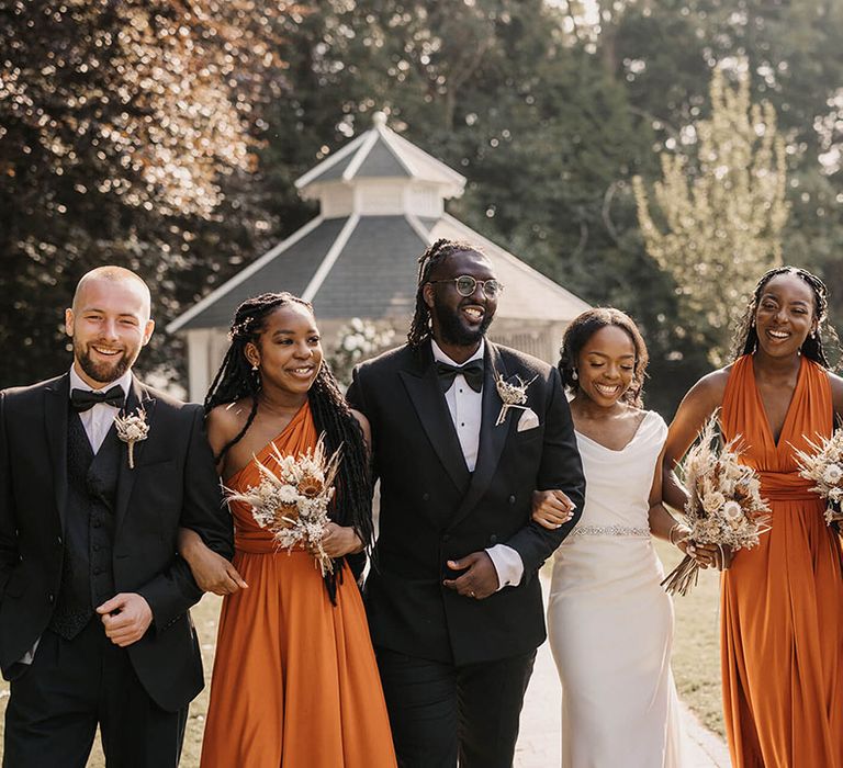 Bride & groom stand with their wedding party on their wedding day