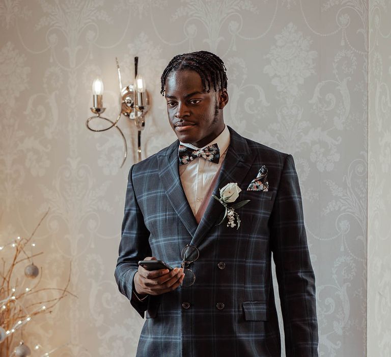 Groomsmen wears tartan suit complete with floral buttonhole 