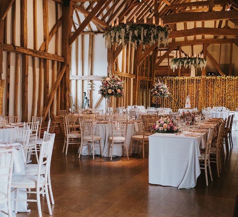 Exposed beam country house wedding venue with pink and copper tablescape with hanging flowers and centrepieces